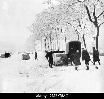 Autos stecken im Schnee in Pease Pottage, 1963 Stockfoto