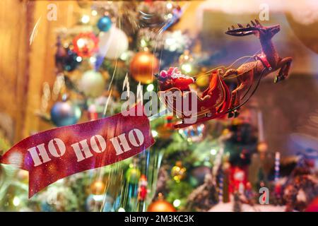 Die Figur des Weihnachtsmanns ist auf einem Schlitten mit der Inschrift ho-ho-ho. Das Konzept von Weihnachten und Neujahr. Stockfoto