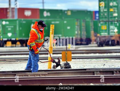 Franklin Park, Illinois, USA. Ein Bahnarbeiter, der manuell einen Hofschalter auf ein Führungsgleis wirft, damit eine Lokomotive zu einem anderen Gleis geführt werden kann. Stockfoto