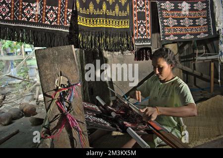 Wenty Fattu produziert traditionelle Textilien von Rote Island in ihrer Werkstatt im Dorf Ndao, Rote Island, Regency Rote Ndao, Provinz East Nusa Tenggara, Indonesien. Jeden Monat produziert ihre Familie drei Stoffe, die zwischen 300.000 und 500.000 IDR kosten. Stockfoto