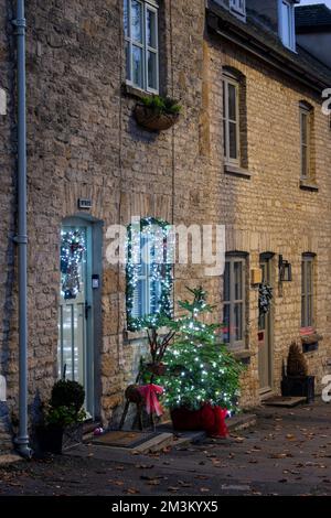 Weihnachtsdekorationen vor einer Hütte bei Nacht. Stow on the Wold, Cotswolds, Gloucestershire, England Stockfoto