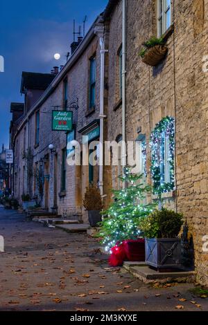 Weihnachtsdekorationen vor einer Hütte bei Nacht. Stow on the Wold, Cotswolds, Gloucestershire, England Stockfoto