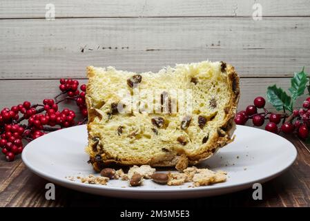 Ein Stück des traditionellen Weihnachtspanettone. Berühmtes italienisches Dessert isoliert auf Holzhintergrund Stockfoto