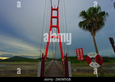 Rote Hängebrücke des Agongdian Reservoir. Das erste Reservoir, das nach dem Zweiten Weltkrieg in Taiwan fertiggestellt wurde Kaohsiung City, 2022 Stockfoto