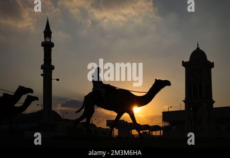 Sicherheitskräfte mit ihren Kamelen auf einer Wiese vor dem Amiri Diwan, dem offiziellen Arbeitsplatz und dem Büro des Emirs des Staates Katar im Sonnenuntergang Sicherheitskräfte mit ihren Kamelen auf einer Wiese vor dem Amiri Diwan, Der offizielle Arbeitsplatz und das Büro des Emir des Staates Katar bei Sonnenuntergang Fussball WM 2022 in Katar FIFA Fußball-Weltmeisterschaft 2022 © diebilderwelt / Alamy Stock Stockfoto