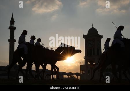 Sicherheitskräfte mit ihren Kamelen auf einer Wiese vor dem Amiri Diwan, dem offiziellen Arbeitsplatz und dem Büro des Emirs des Staates Katar im Sonnenuntergang Sicherheitskräfte mit ihren Kamelen auf einer Wiese vor dem Amiri Diwan, Der offizielle Arbeitsplatz und das Büro des Emir des Staates Katar bei Sonnenuntergang Fussball WM 2022 in Katar FIFA Fußball-Weltmeisterschaft 2022 © diebilderwelt / Alamy Stock Stockfoto