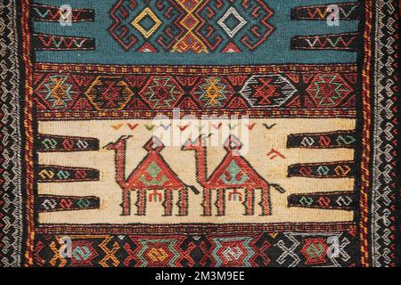 Farbenfroher Orientalischer Mosaikteppich Mit Traditionellen Tierornament. Gemusterter Teppich. Teil Des Orientalischen Teppichs. Nahaufnahme Des Handgefertigten Gewebes Stockfoto