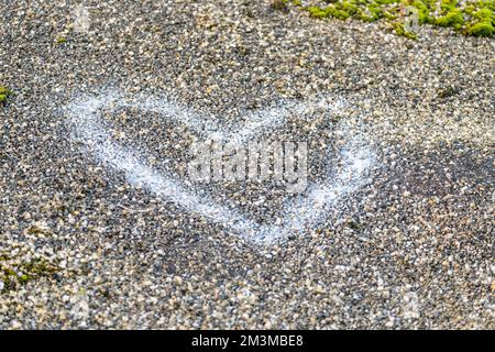 Die weiße Form eines Herzens auf der Oberfläche einer Straße als Symbol der Liebe. Stockfoto