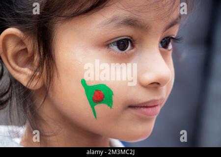 Narayanganj, Dhaka, Bangladesch. 16.. Dezember 2022. Ein bangladeschisches Kind mit einer Nationalflagge, die anlässlich des 52.. Siegesfeiertages in Narayanganj, Bangladesch, gemalt wurde, der das Ende eines bitteren neunmonatigen Unabhängigkeitskriegs von Pakistan markiert. Bangladesch feiert den 52.. Jahrestag seines nationalen Sieges und erinnert an die tapferen Freiheitskämpfer, die kämpften und das ultimative Opfer brachten, um das Land von den pakistanischen Truppen zu befreien. Menschen aus allen Gesellschaftsschichten versammeln sich am Morgen im Narayanganj Central Shaheed Minar, um den wertvollsten Tag des Bangali People Cr zu feiern Stockfoto