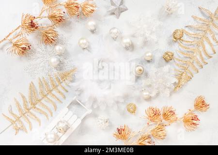 Weihnachtlicher Hintergrund mit Ornamenten, Bällen und, Draufsicht in Weiß- und Goldtönen Stockfoto