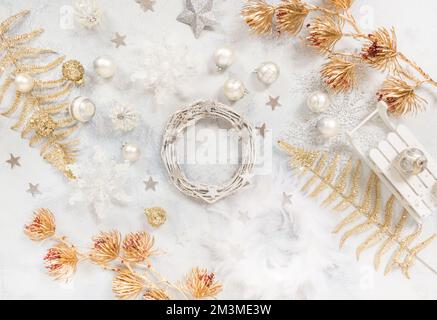 Weihnachtlicher Hintergrund mit Ornamenten, Bällen und, Draufsicht in Weiß- und Goldtönen Stockfoto