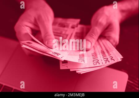 Geschäftsmann, der Geld zählt. Reiche männliche Hände halten und zählen Bargeld-Banknoten von 50-Euro-Scheinen oder Scheinen. Getönt in Viva Magenta, Trendfarbe von Stockfoto