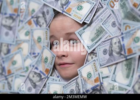 Amerikanische Träume. Kopf in Geld. Lustiges Kindergesicht auf Dollargeld. Stockfoto