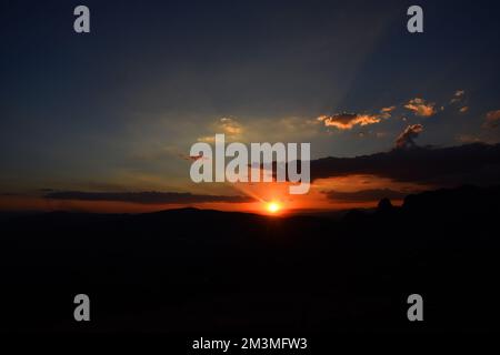 Nicht exklusiv: Die Sonne geht während des Sonnenuntergangs im Winter hinter den Bergen unter, um die Landschaft in der bergigen Gegend von Tepoztlan zu genießen. - Nein Stockfoto