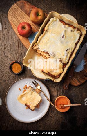 Hausgemachter Brotpudding Frühstücksauflauf mit Äpfeln und Zimt und Eiweißglasur Stockfoto