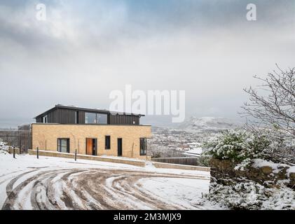Edinburgh, Schottland, Großbritannien - Observatory Road House von Zone Architects mit Arthur's Seat im Winterschnee Stockfoto