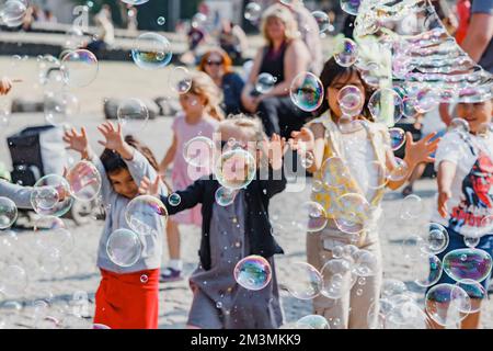 29. Juli 2022, Köln, Deutschland: Ein Straßenkünstler macht eine Vorstellung und eine Seifenblasenshow für Kinder, die Spaß haben Stockfoto