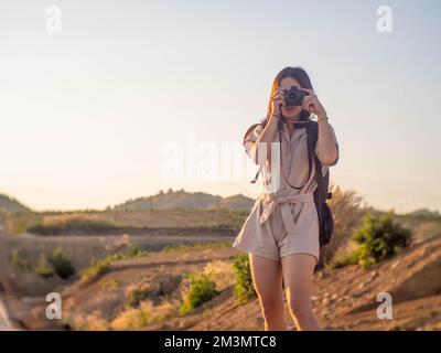 Eine Frau, die einen Rucksack trägt und Fotos fotografiert Stockfoto