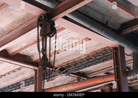 Ketten an der Decke im industriellen Innenraum Stockfoto