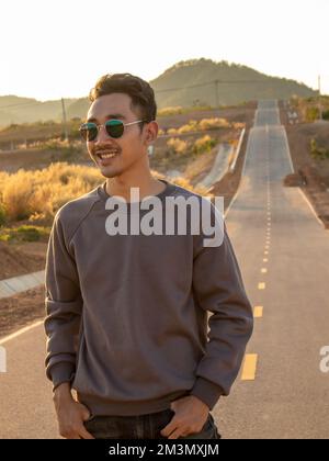 Ein Mann mit Brille steht mitten auf der Straße. Stockfoto