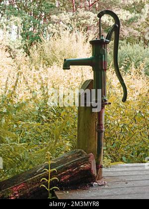 Eine altmodische Wasserpumpe an einem klaren Fluss namens Itter in Deutschland Stockfoto