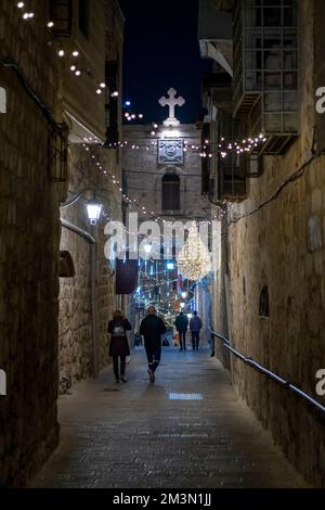 Die Menschen spazieren durch die griechische Patriarchatenstraße, die mit Weihnachtslichtern im christlichen Viertel dekoriert ist. Altstadt Ost-Jerusalem Israel Stockfoto