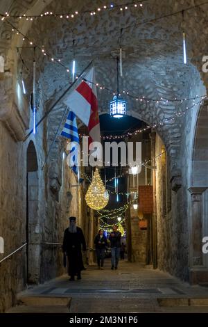 Die Menschen spazieren durch die griechische Patriarchatenstraße, die mit Weihnachtslichtern im christlichen Viertel dekoriert ist. Altstadt Ost-Jerusalem Israel Stockfoto