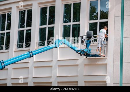 27. Juli 2022, Essen, Deutschland: Ein Arbeiter malt ein historisches Gebäude in der Altstadt. Restaurierung und Reparatur Stockfoto