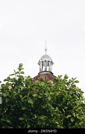 Ein vertikales Bild eines alten, antiken Glockenturms mit Wetterfahne oben in Frankreich Stockfoto