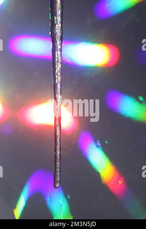 Eiszapfen schmelzen im bunten Licht Stockfoto