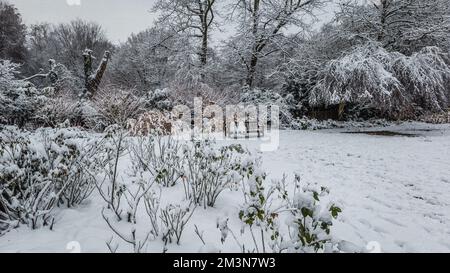 Wunderschöne Winterszene im Londoner Hampstead mit zwei Schneemännern auf einer Parkbank nach dem ersten Schnee von 2022. Stockfoto