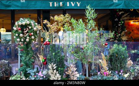 Das Ivy Soho Brasserie Restaurant mit Weihnachtsdekorationen Kranz, Pflanzen in Töpfen draußen auf der Broadwick Street London England 2022 KATHY DEWITT Stockfoto