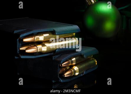 Komplette Sturmgewehre-Magazine mit Weihnachtsschmuck dahinter Stockfoto