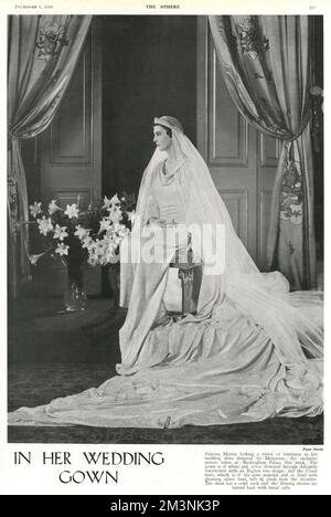 Prinzessin Marina von Griechenland sieht in ihrem Hochzeitskleid, das von Captain Edward Molyneux entworfen wurde, eine Vision von Schönheit in einem Foto, das in der Woche vor ihrer Hochzeit mit Prinz George, Herzog von Kent in Westminster Abbey am 29. November 1934, im Buckingham Palace aufgenommen wurde. Das Kleid bestand aus weißem und silbernem Brokat, der mit einem englischen Rosenmuster verwoben war. Der Court Train aus demselben Material und mit silbernem Lahm gefüttert fiel 4 m und 1/2 m von der Schulter. Das Kleid hatte einen Wasserfallausschnitt und nach hinten fließende Ärmel mit breiten Bündchen. Datum: 1934 Stockfoto