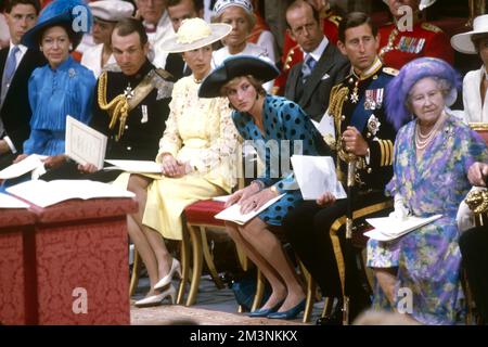 Diana, Prinzessin von Wales, lehnt sich in ihrem Sitz weiter nach vorn als die anderen Mitglieder der königlichen Familie, um einen Blick auf die herannahende Braut Sarah Ferguson zu erhaschen, die am 23. Juli 1986 Prinz Andrew, Herzog von York, in Westminster Abbey heiratete. 1986 Stockfoto