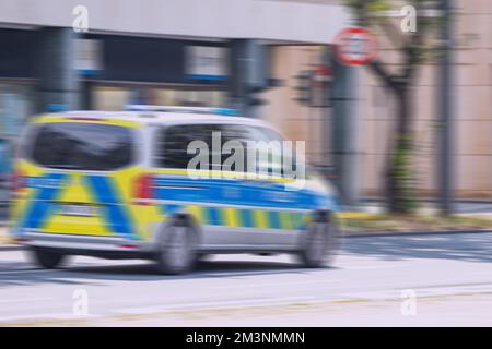 Der Bewegungsunschärfe eines deutschen polizei- oder Polizeiwagens rennt auf der Straße herum. Unfall- und Geschwindigkeitskonzept Stockfoto