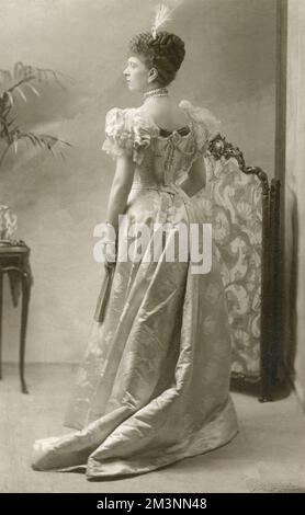 Studioporträt von Queen Mary (1867 - 1953), möglicherweise noch als Prinzessin May of Teck. Sie zeigt eine Rückansicht, während sie ein elegantes Abendkleid trägt und einen Ventilator in der Hand hält. Datum: c.1890 Stockfoto