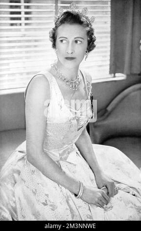 Die Gräfin von Leicester, zuvor Lady Elizabeth Yorke (1912 - 1985), die bei ihrer Krönung als Lady des Schlafzimmers der Königin Elizabeth II. Fungierte, stellte sich das Kleid von Norman Hartnell vor, das sie bei dieser Gelegenheit trug. Sie wurde von Norman Hartnell entworfen und war aus einer weiß-goldenen französischen Lahmheit mit einem Blattdesign. Datum: 1953 Stockfoto