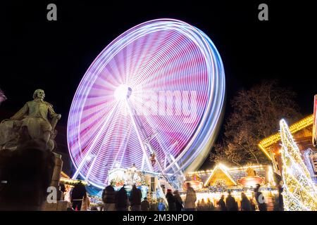 Malerischer Blick auf den traditionellen deutschen Weihnachtsmarkt in Magdeburg mit heller Dekoration, beleuchtetem Riesenrad und historischem Otto-Denkmal Stockfoto