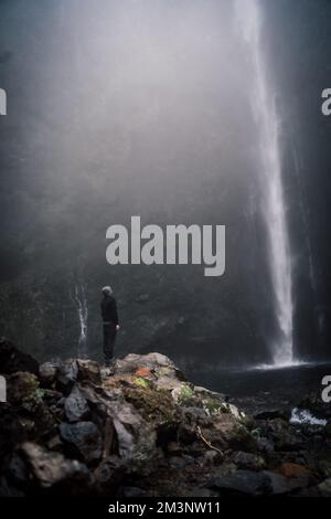 Eine Person, die vor einem Wasserfall auf madeira steht Stockfoto