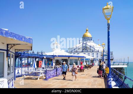 Eastbourne East Sussex Menschen, die am Eastbourne Pier vorbei an den Tearooms am Eastbourne Pier Eastbourne East Sussex England GB Europa spazieren Stockfoto