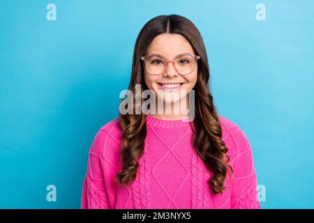 Foto eines jungen, hübschen, intelligenten Nerds Schulmädchen Akademikerin tragen Brille zufriedene lächelnde Dame tragen pinkfarbenen Pullover isoliert auf blauem Hintergrund Stockfoto