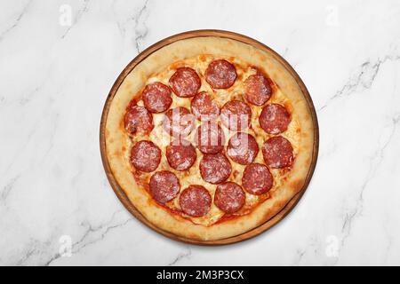 Peperoni-Pizza auf Holzbrett auf grauem Hintergrund Stockfoto
