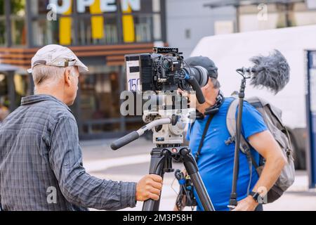 28. Juli 2022, Essen, Deutschland: Kameramann mit seinem Team im Gespräch auf der City Street. Fernsehen und Journalist Stockfoto