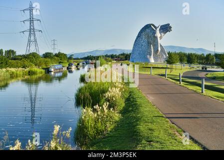 Die Kelpies mit hellen und bunten wilden Blumen am Forth und Clyde Canal Ufer. Helix Public Park, Falkirk, Stirlingshire, Central, Schottland, VEREINIGTES KÖNIGREICH. Stockfoto