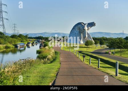 Die Kelpies mit hellen und bunten wilden Blumen am Forth und Clyde Canal Ufer. Helix Public Park, Falkirk, Stirlingshire, Central, Schottland, VEREINIGTES KÖNIGREICH. Stockfoto