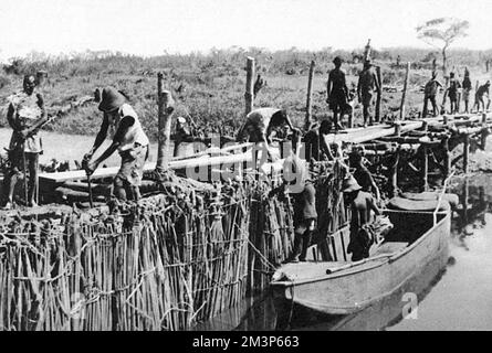 Örtliche Arbeiter bauen einen provisorischen Staudamm am Fluss Dangu im belgischen Kongo (Zaire). Der Damm wurde gebaut, um einen See zu schaffen, damit das fliegende Boot „Corsair“ starten konnte. Das Flugboot Imperial Airways hatte im März 1939 eine Zwangslandung durchgeführt und wurde zunächst als nicht reparierbar angesehen, und die Anordnung, es abzubauen, wurde erteilt. Ein Firmeningenieur aus Alexandria dachte etwas anderes, und es wurden Reparaturen durchgeführt und ein erster Damm errichtet. Der Startversuch im Juni 1939 ist gescheitert, und es kam zu weiteren Schäden. Nach weiteren Repaiern und dem Bau eines zweiten Dammes, dem SE Stockfoto