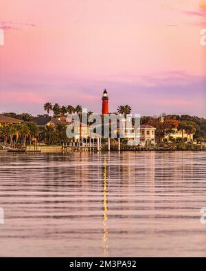 Der Blick auf Häuser und Palmen am Ufer mit Ponce de Leon Inlet Light im Hintergrund. Florida, USA. Stockfoto
