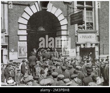 Szenen vor dem zentralen Rekrutierungsbüro in Whitehall, wo etwa 200 Männer aus Cornwall nach London gereist waren, um sich 1915 für das Derby-Programm zu engagieren. Beachten Sie das berühmte „Take Up the Sword of Justice“-Rekrutierungsposter auf beiden Seiten des Eingangs. Stockfoto