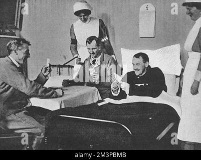 Britische Krankenschwestern, die dem St. Johns freiwillige Hilfsorganisation in Frankreich schaut zur Unterhaltung auf eine Gruppe verwundeter und erholsamer Soldaten, die ein Kartenspiel (Nickerchen) spielen. Die Männer tragen die bekannte blaue Uniform der Verwundeten im Ersten Weltkrieg. Datum: 1916 Stockfoto